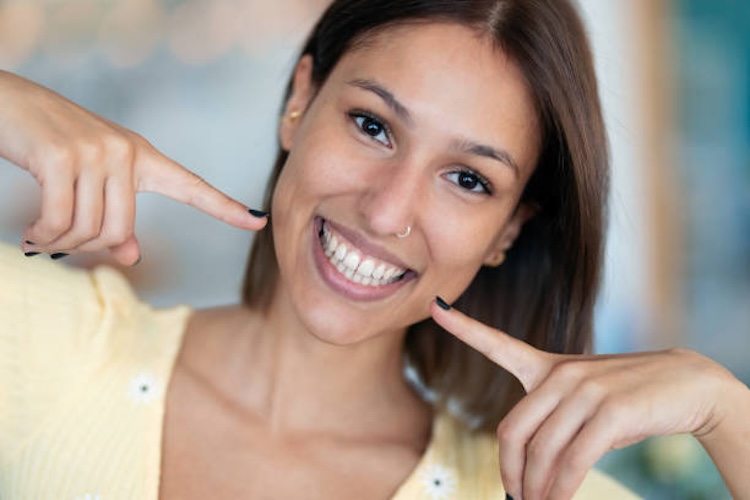 Portrait of beautiful young woman with perfect white smile looking at camera at home.